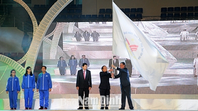 The National Games flag is presented to a representative of the southern province of An Giang, the host of the 8th National Games. 