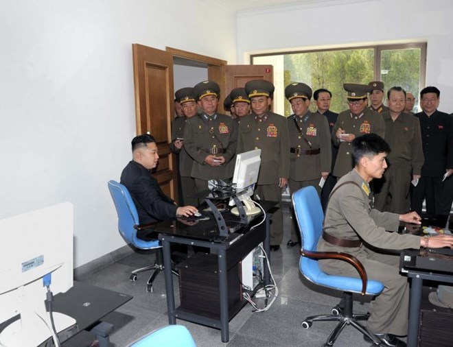 Nhà lãnh đạo Triều Tiên Kim Jong Un (trái) sử dụng máy tính trong chuyến thăm một đơn vị quân đội. (Nguồn: KCNA)