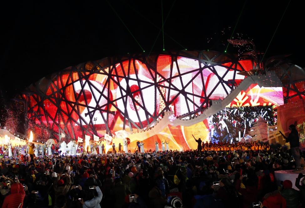 Performers and attendees celebrate the arrival of the new year in front of the National Stadium, also known as the "Bird's Nest", on which the year 2015 is projected, during a new year's countdown event celebrating the arrival of the new year and wishing in winning the bid to host the 2022 Winter Olympic Games, in Beijing January 1, 2015. 