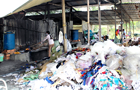 Công nhân đang đưa rác vào lò nấu muối tại nhà bà Nguyễn Thị Cúc.