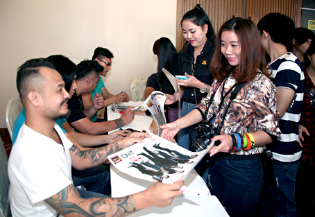 Nhạc sĩ - ca sĩ Trần Lập (trái) ký tặng hình cho khán giả TP.Biên Hòa tại buổi họp báo chương trình Rock Storm7.