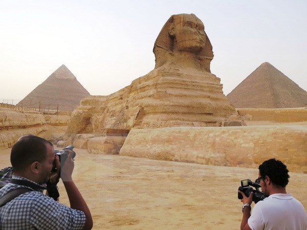 Tượng Nhân sư bên cạnh kim tự tháp Menkaure (phải) và Khafre (trái) tại Giza, ngoại ô thủ đô Cairo ngày 9/11. (Nguồn: Kyodo/TTXVN)