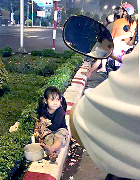 Bé gái 3 tuổi vô tư ngồi gần cổng A42 chờ người đi đường bố thí.