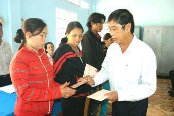 Chairman Vy Van Vu of the provincial Fatherland Front Committee presents Tet gifts to the poor.