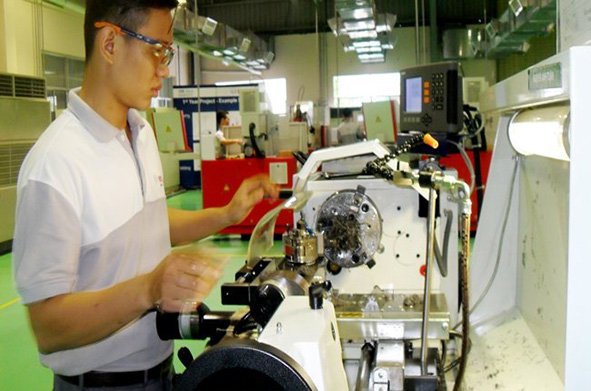 An employee is at work at a foreign invested firm manufacturing supporting items for the automobile industry in Dong Nai Province