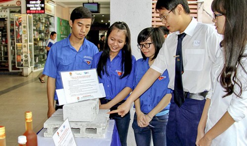 Nguyen Cao Hoang Sang (2nd from R) introduces his unburned bricks from waste paper