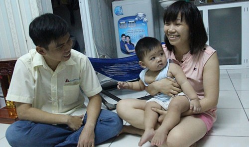 A worker couple are happy with their child in an affordable apartment they bought by installments from a social housing program in Binh Duong Province.