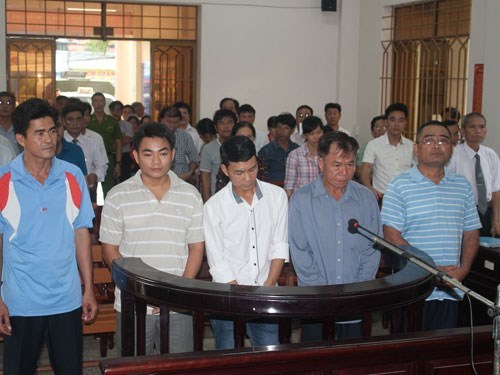 Five defendants stand in a courtroom in the southern province of Dong Nai. They were later sentenced to prison for causing a train-cars collision that killed 2 and injured 22 in 2011.