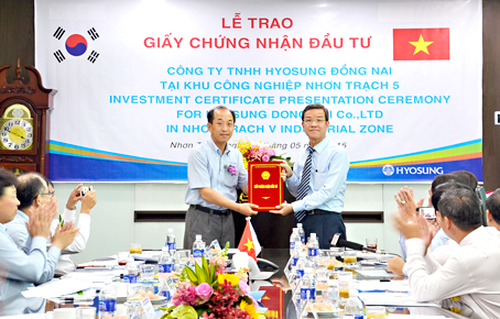 Chủ tịch UBND tỉnh Đinh Quốc Thái (phải) trao giấy chứng nhận đầu tư cho đại diện Công ty Hyosung Đồng Nai. Ảnh:  K.Giới