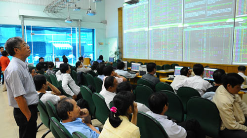 People watch transactions at a stock trading floor. The Ministry of Finance is drafting a circular to regulate the sale of shares lots offered by equitising state-owned enterprises.