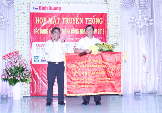 Tổng biên tập Báo Bình Dương Nguyễn Quang Hiệp (trái) trao cờ luân lưu đăng cai cho đại diện báo Bà Rịa - Vũng Tàu