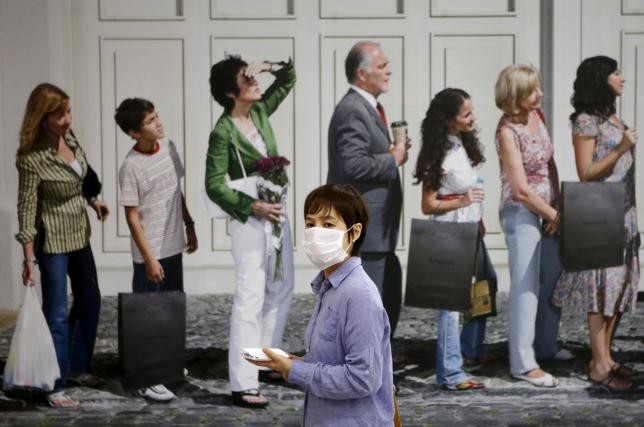 Một phụ nữ Hàn Quốc đeo khẩu trang để ngừa virus MERS khi bước xuống trung tâm mua sắm dưới lòng đất ở thành phố Seoul hôm 19/6. Ảnh: Reuters