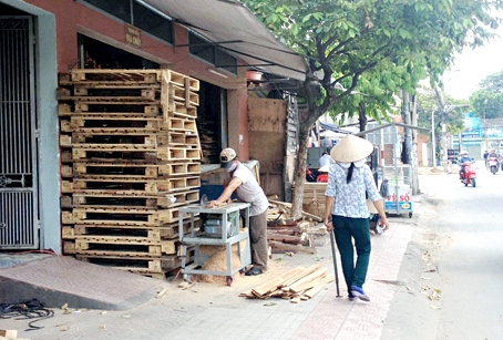 Hộ ông Nguyễn Văn Huỳnh chế biến sản phẩm từ gỗ ngay trên vỉa hè.Ảnh: K.Liễu