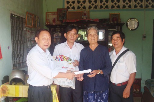 Dong Tien Garment Company’s representative presents gifts to the family of Ms Pham Thi Tu in Long Tan commune.