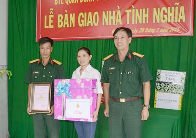 Senior Lieutenant Phung Ngoc Dung (left) receives the house.