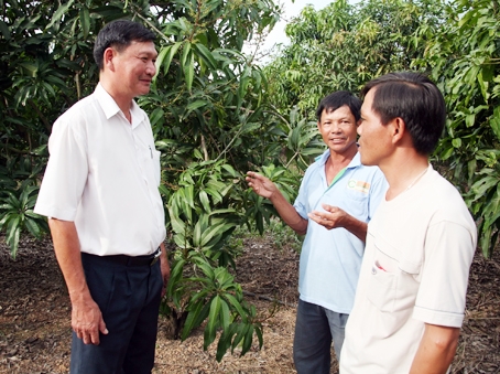 Ông Lý Văn Ngọc (bìa trái) đến thăm và trao đổi với các hộ dân về sản xuất nông nghiệp tại ấp Phú Quý 2, xã La Ngà.  Ảnh: V. Truyên