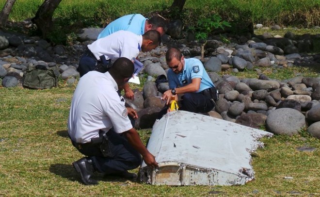 Nhân viên điều tra nghiên cứu mảnh vỡ máy bay tìm thấy. (Nguồn: AFP/Getty Images)