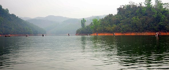 Local residents are seen on their boats catching ﬁ sh in Cam Son Lake