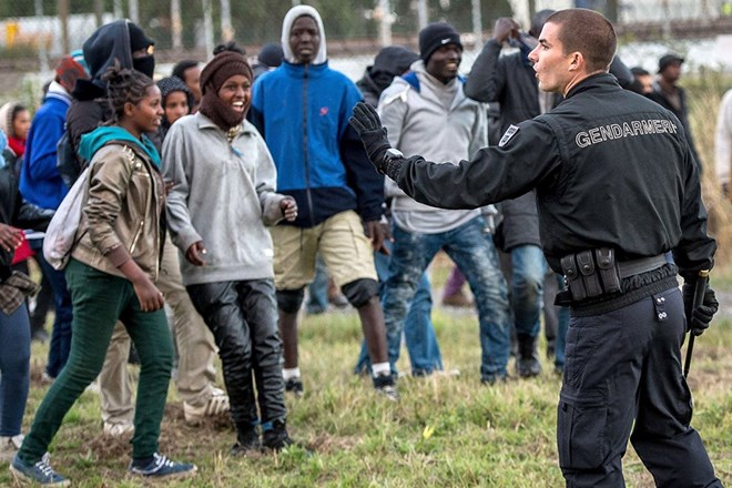 Cảnh sát cố gắng ngăn cản những người di cư tiếp cận đường đường ray tại Coquelles gần Calais. (Nguồn: AFP)