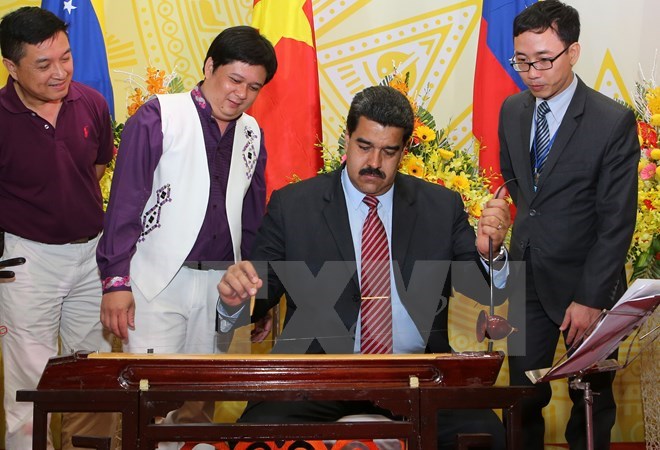 Venezuelan President Nicolás Maduro Moros plays monochord, a Vietnamese traditional musical instrument during his visit to Vietnam from August 31 to September 1. (Source: VNA)