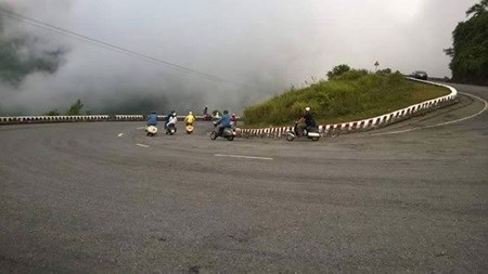 Vespa scooter drivers take a curve on the Hai Van Pass in an off-road tour.