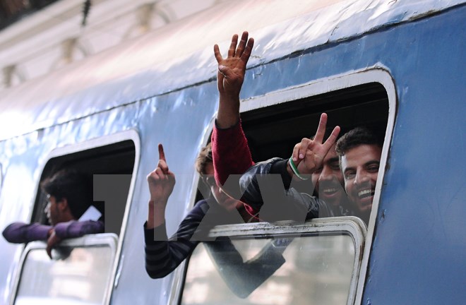 Người di cư vui mừng sau khi được lên tàu tới biên giới Hungary-Áo ngày 5/9. (Nguồn: AFP/TTXVN)