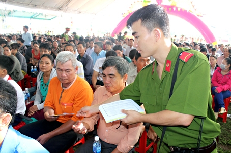 Công an cấp tờ rơi vận động người dân tố giác tội phạm tại xã Phú Tân (huyện Định Quán).