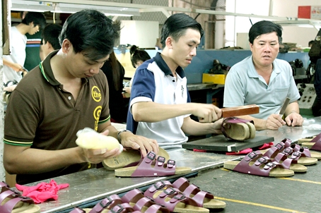 Công nhân sản xuất giày dép tại Công ty cổ phần giày dép cao su màu (TP. Biên Hòa).