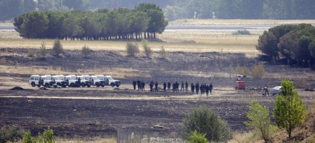 Spanish civil guards patrol a section of the Spanair's Flight JK5022 crash area inside Barajas airport in Madrid in this August 21, 2008.