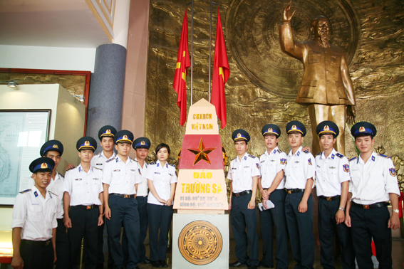 Cán bộ, chiến sĩ Cảnh sát biển Vùng 3 chụp hình lưu niệm bên hiện vật được trưng bày tại triển lãm.