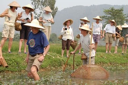 Tourists enjoy outdoor activities during their homestay tour in Van Long district in Ninh Binh province 