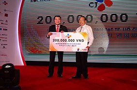 A representative of KoCham (L) hands over a symbolic check to a representative of HCMC’s Relief Association for Disabled Children during the KoCham Charity Night on Saturday 