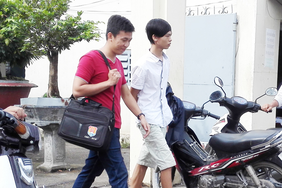 Nguyễn Công Thành (áo trắng) được công an đưa về trụ sở để phục vụ công tác điều tra.