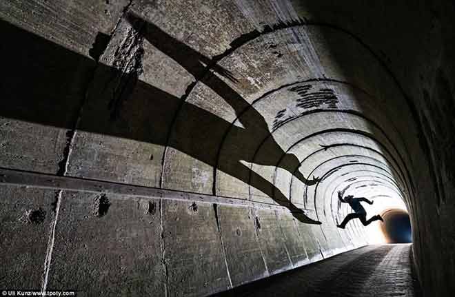 A Moment in Light - Winner - Photographer Uli Kunz from Germany took this striking image of a jumping man casting a long shadow on tunnel walls in Heligoland, North Sea.