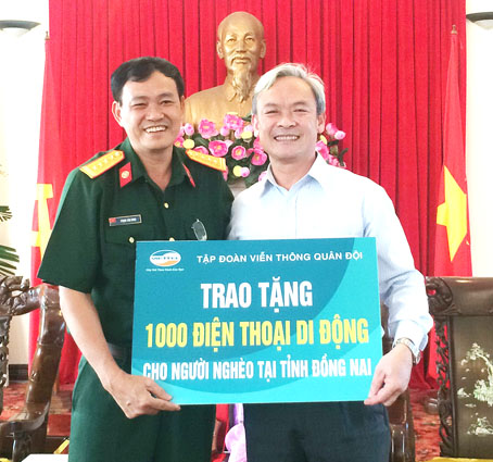 Bí thư Tỉnh ủy Nguyễn Phú Cường tiếp nhận biểu trưng ủng hộ 1 ngàn điện thoại di động từ lãnh đạo Tập đoàn Viễn thông quân đội. Ảnh: Xuân Hà