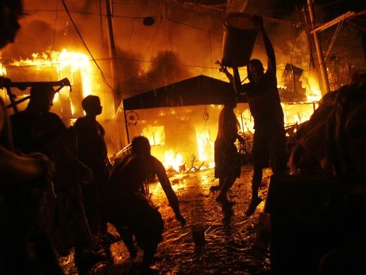 Người dân tham gia chữa cháy tại khu ổ chuột Tondo ở Manila. (Nguồn: AP)