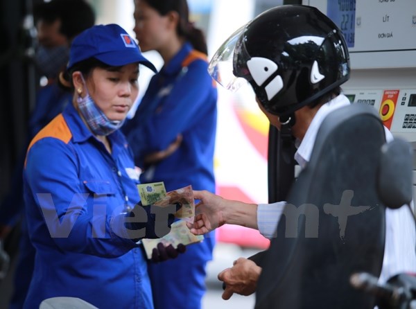 Nhân viên Petrolimex bán xăng cho khách hàng. (Ảnh: Đức Duy/|Vietnam+)