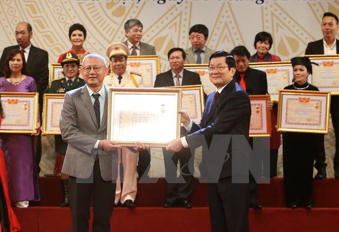 President Truong Tan Sang (R) presents People’s Artist title to artists (Source: VNA)