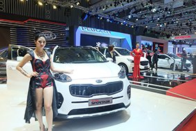 Models stand next to cars assembled and distributed by Thaco at the Vietnam Motors Show in HCMC last year. Thaco became Vietnam’s biggest auto seller last year with 80,421 units sold.