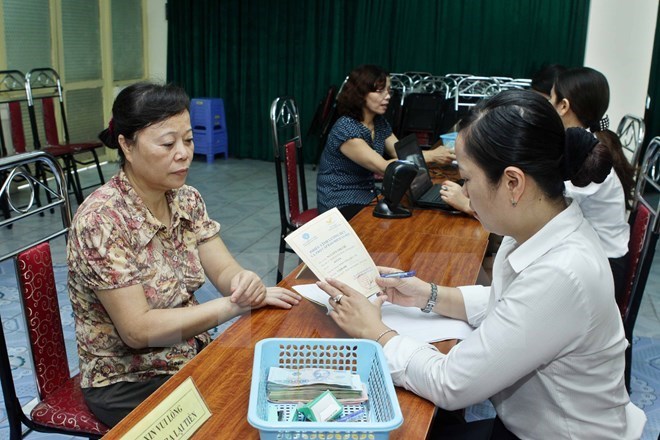 A woman (L) waits to receive pension, social insurance benefits (Photo: VNA)