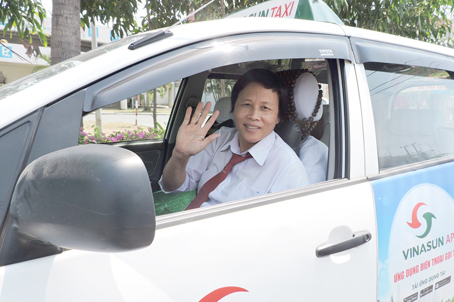 Chị Nguyễn Thị Hằng tươi cười bên chiếc xe taxi của mình.