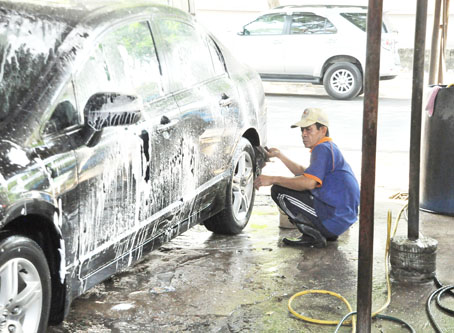 Nhân viên một tiệm rửa xe đang vệ sinh xe ô tô cho khách.