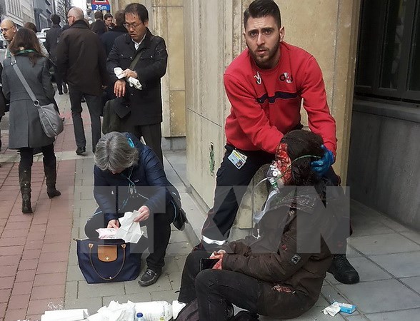 Nhân viên an ninh hỗ trợ người bị thương sau vụ nổ ở ga tàu điện ngầm Maalbeek ở Brussels ngày 22/3. (Nguồn: AFP/TTXVN)