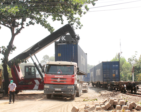 Cần cẩu đang bốc dỡ container từ xe đầu kéo lên toa tàu ở Ga Trảng Bom.  Ảnh: P.LIỄU