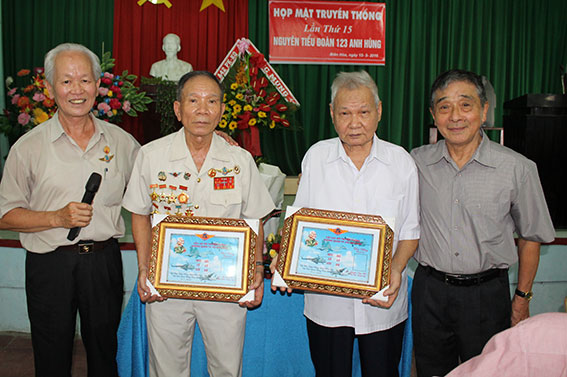 Ông Vũ Đình Lầu (người thứ hai từ phải qua), một trong những người làm công tác kỹ thuật đầu tiên của phi đội Quyết Thắng nhận một bức ảnh kỷ niệm từ một đồng đội tặng.