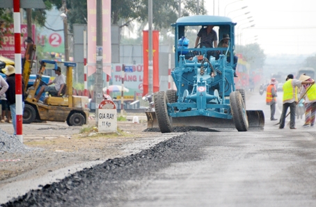 Đơn vị thi công đang cho cào bóc mặt đường trồi lún đoạn qua xã Xuân Phú (huyện Xuân Lộc).