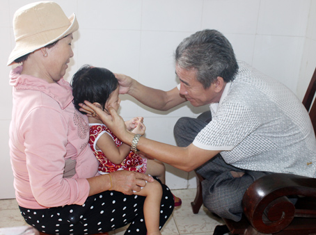 Lương y Nguyễn Trên bấm huyệt cho một trẻ bị liệt dây thần kinh số 7, giúp 2 mắt của cháu bé bị lé đã dần trở lại bình thường.  Ảnh: A.An