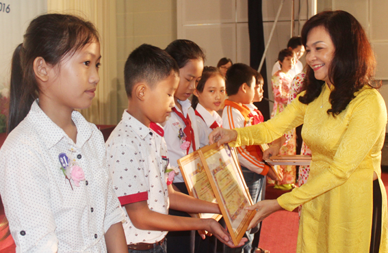 The organizing board's representative presents gifts to students.