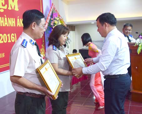 Cục trưởng Cục công tác phía Nam (Bộ Tư pháp) Nguyễn Thanh Bình trao kỷ niệm chương và giấy khen của Bộ Tư pháp cho các chấp hành viên. Ảnh: Đ.PHÚ