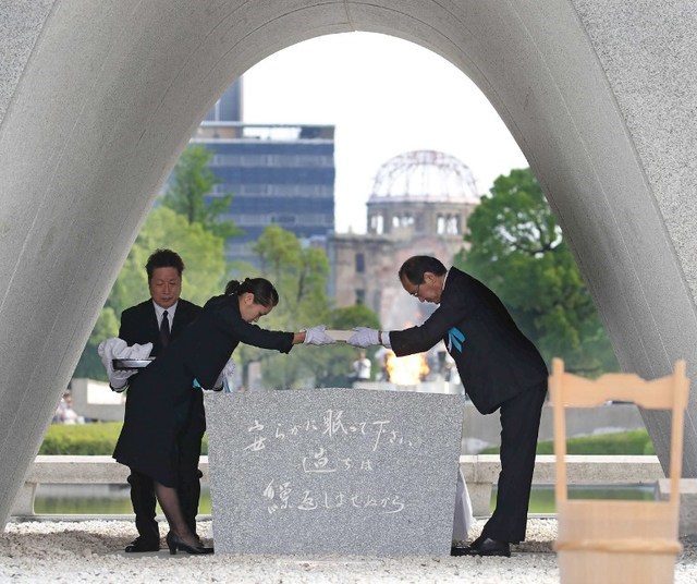 Thị trưởng Hiroshima Kazumi Matsui (phải) trao danh sách mới về những nạn nhân bom nguyên tử cho một nạn nhân tại Công viên tưởng niệm Hòa bình. (Nguồn: AFP)